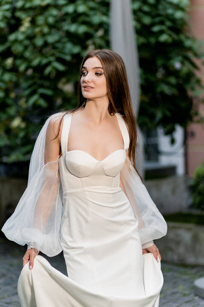 beautiful young woman in white dress posing outdoors - Фото, зображення