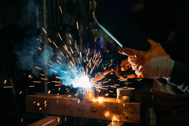 Industrial welder worker welding steel or iron in a factory - 写真・画像