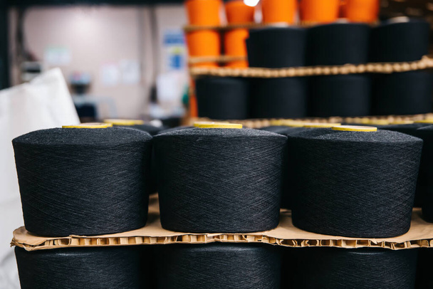 Colorful cotton yarns or threads on spool tube bobbins at cotton yarn factory - Fotoğraf, Görsel