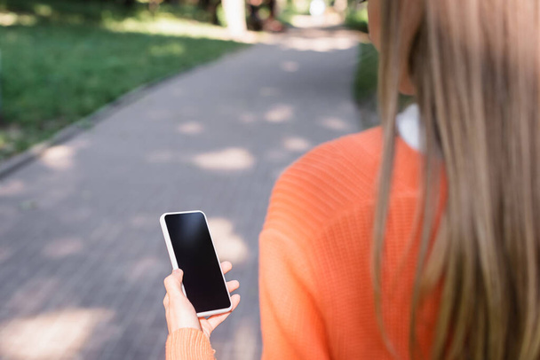обрезанный вид женщины, держащей смартфон с пустым экраном
 - Фото, изображение