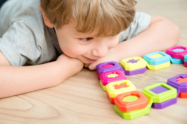 Barevné domino tvary hra. Childs ruku na dílu, spojuje kousky skládačky. Montessori typ vzdělávací hračka. Pěkné motorické brusle. Rozvoj dítěte s dětským smyslem. - Fotografie, Obrázek