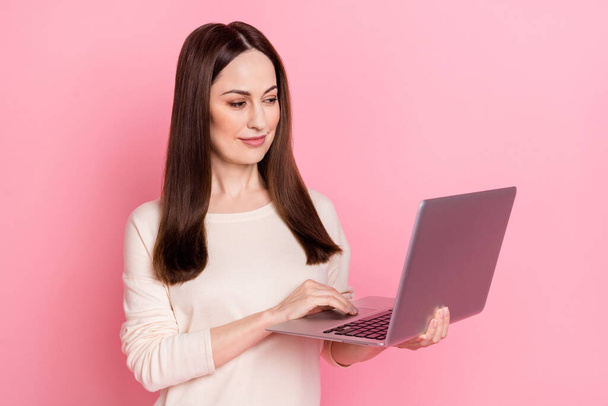 Photo of pretty woman it specialist hold laptop buy online home based business wear nice pullover isolated pink color background - Φωτογραφία, εικόνα