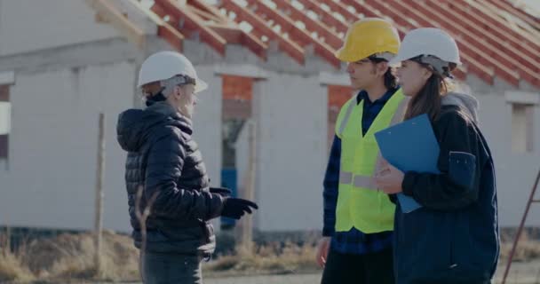 Female civil engineer greeting building contractor and worker with handshakes - Footage, Video