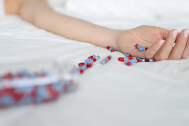 Young woman committing suicide by overdosing on medication - 写真・画像