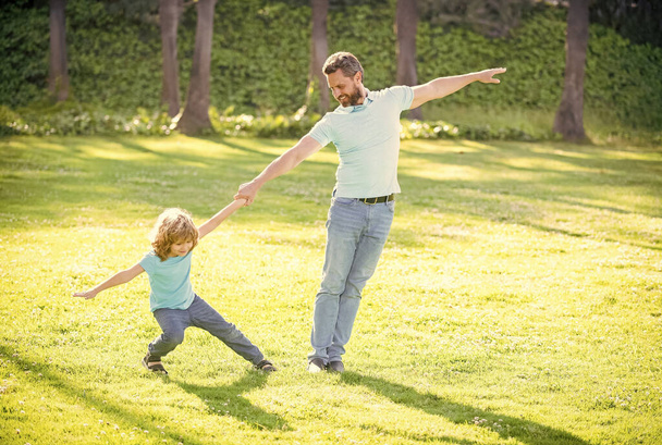 Ευτυχισμένο παιδί αγόρι τραβήξτε το χέρι του πατέρα παίζει σε εξωτερικούς χώρους καλοκαίρι, διασκέδαση - Φωτογραφία, εικόνα