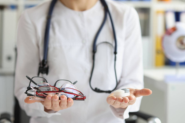 Женщина-врач делает выбор между контактными линзами и очками - Фото, изображение