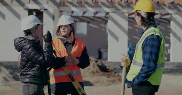 Naisinsinööri keskustelee rakennustyötovereiden kanssa - Materiaali, video