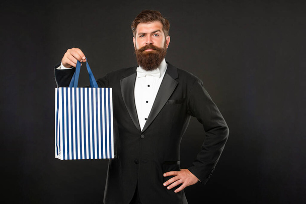 smiling man in tuxedo bow tie with business reward in shopping bag. occasion greeting. copy space. - 写真・画像