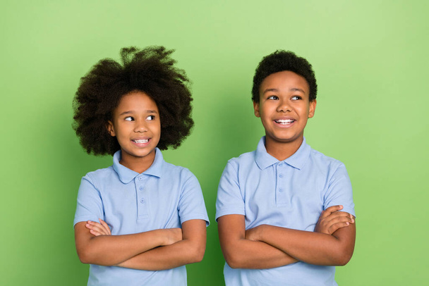 Portrait of two attractive cheerful trendy pre-teen pupils folded arms lesson think isolated over green color background - Photo, Image