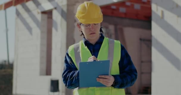 Young male contractor writing on clipboard - Footage, Video