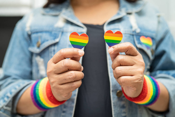 Asiatische Dame mit Herz mit Regenbogenfahne, Symbol des LGBT-Stolzes Monat feiern jährlich im Juni soziale Schwule, Lesben, Bisexuelle, Transgender, Menschenrechte. - Foto, Bild
