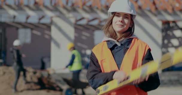 Confident female supervisor carrying level tool on shoulder - Séquence, vidéo