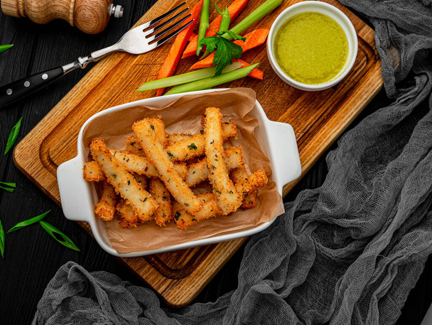Fish sticks with fresh vegetables on a wooden board. Serving food in the restaurant. Healthy food. Photo for the menu. - Photo, Image