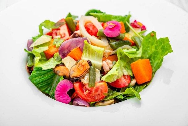 Salade met zeevruchten en verse groenten. Gezond saladebord. Salade met verse groenten, mosselen, garnalen en inktvissen - Foto, afbeelding