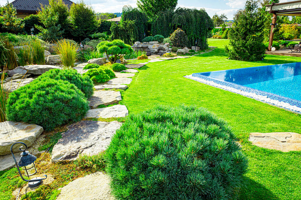 Quintal com piscina residencial ao ar livre inground, jardim, deck e pátio de pedra
 - Foto, Imagem