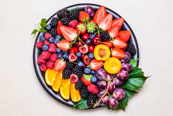 Fruits and berries assortment in plate copy space background.Healthy colorful delicious snack. - Photo, image