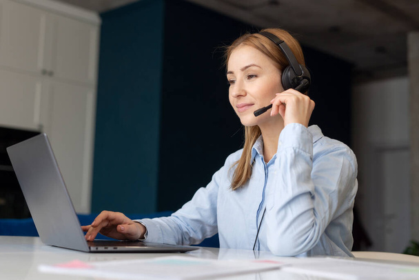Portrait of woman with laptop and headset working as call center operator. Remote work. Customer support service worker. Problems solving concept - Photo, Image