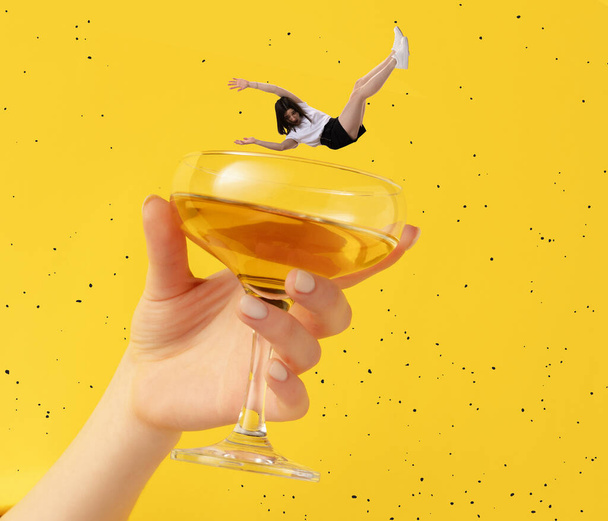 Contemporary art collage. Young woman falling into delicious cocktail isolated over yellow background - Fotó, kép