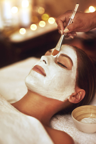 Let your beauty rise to the surface. Shot of a young woman enjoying a facial treatment at the spa. - Foto, imagen
