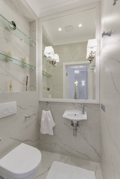 Washbasin in the bright bathroom with light marble and white towel - Photo, Image