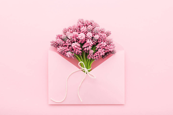 Spring flowers in a pink envelope for Mothers day, flat lay - Foto, Bild