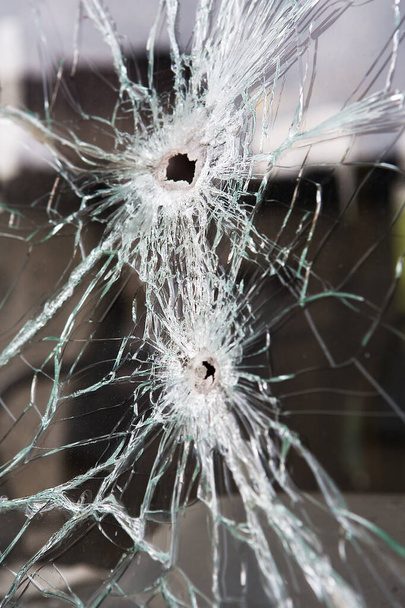 Broken glass with bullet holes. - Foto, Bild