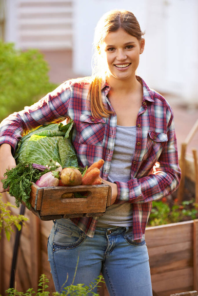 Zezelenal jsi. Portrét šťastné mladé ženy držící bednu plnou čerstvě sklizené zeleniny. - Fotografie, Obrázek