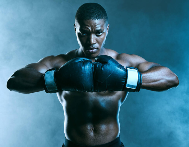 Ik haat het niet, ik domineer. Studio shot van een knappe jonge man boksen tegen een blauwe achtergrond. - Foto, afbeelding
