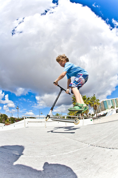 Мальчик со скутером летит по воздуху
 - Фото, изображение