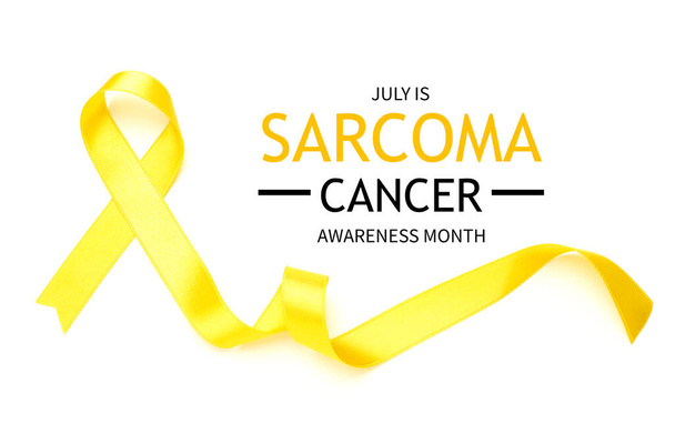 Yellow ribbon and text JULY IS SARCOMA CANCER AWARENESS MONTH on white background - 写真・画像