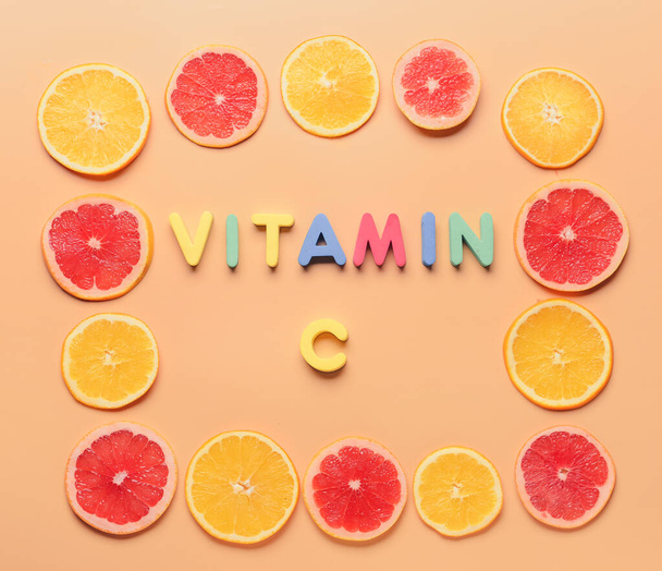 Composition with text VITAMIN C and slices of citrus fruits on color background - Foto, Imagen