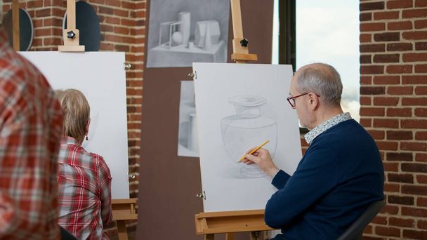 芸術の授業でキャンバスに描く老人と女性 - 写真・画像