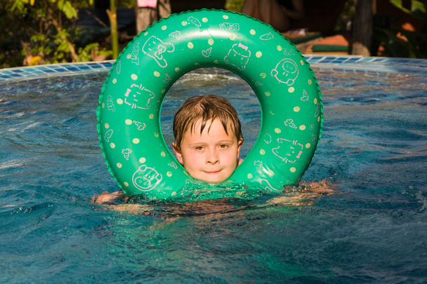 chłopak pływa z pierścieniem w basenie - Zdjęcie, obraz