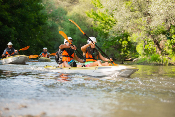 Group senior and adult friends are canoeing while racing each other - Foto, immagini