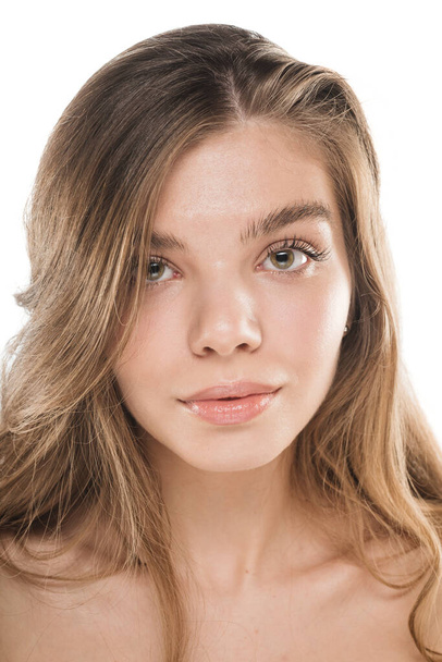 Close up portrait of a beautiful young girl with a fresh skin posing in studio - 写真・画像