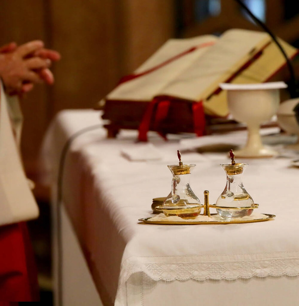 glass cruets above the altar and the priest reading the Bible during Holy Mass in Vatican - Photo, Image