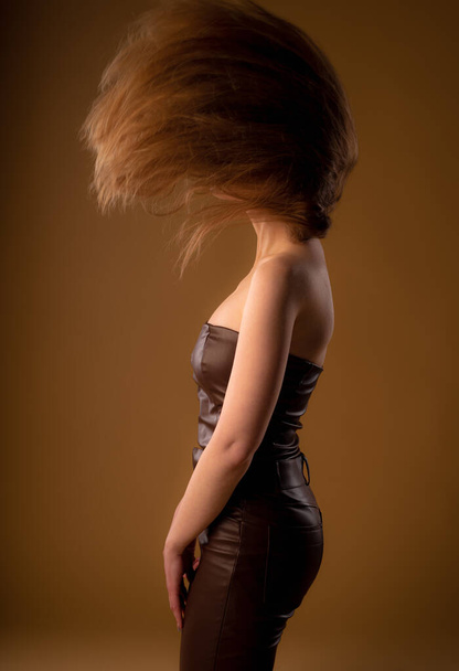 Dziewczyna w studio rzuca włosami stojąc - Zdjęcie, obraz