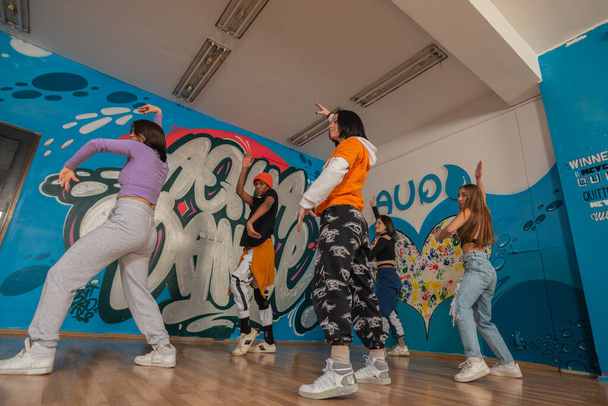 Young dancers in colorful wear having fun dancing hip-hop, enjoy being active. lifestyle, youth generation - Zdjęcie, obraz