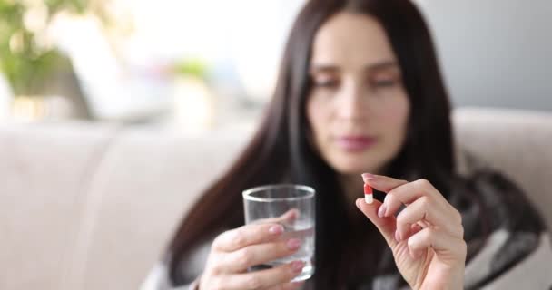 Mujer joven está sosteniendo píldora y vaso de agua - Metraje, vídeo