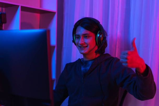 Koncepcja strumienia gry, Mężczyzna Streamer nosić słuchawki i zabawy grać w gry online na żywo strumień. - Zdjęcie, obraz