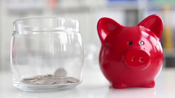 Glass jar piggy bank is filled with coins with piggy bank. - Filmagem, Vídeo