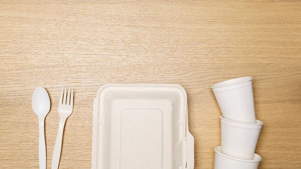 Conceito ecológico, conjunto de recipientes de alimentos e copo de papel biodegradável no fundo de madeira. - Foto, Imagem
