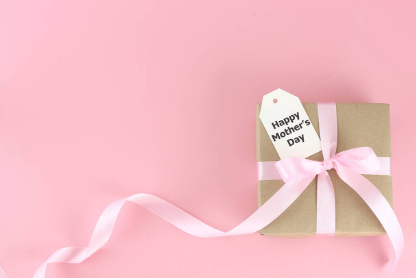 День матері. Верхній вигляд подарункової коробки з рожевими луками - довга стрічка і карта на рожевому фоні з копіювальним простором. Я люблю концепцію мами.. - Фото, зображення