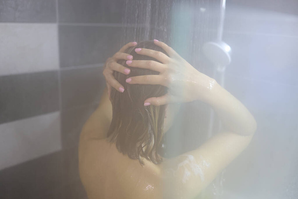 Γυναίκα λάβει ζεστό ντους μετά από σκληρή μέρα, τον καθαρισμό και τη χαλάρωση - Φωτογραφία, εικόνα