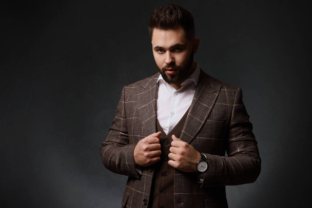 Handsome bearded man in stylish suit on dark background - Fotó, kép