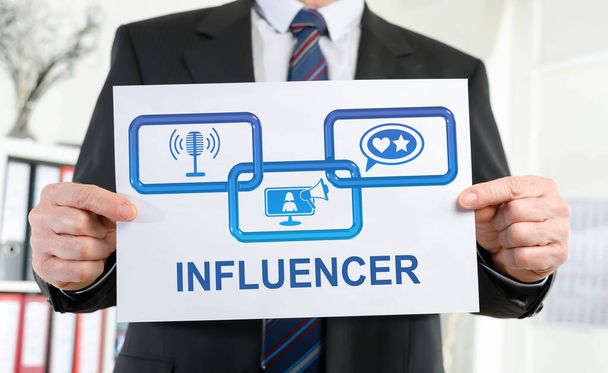 Paper showing influencer concept held by a businessman - Photo, image