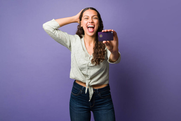 Zaskoczony młoda kobieta krzyczy pokazując najlepszą kartę kredytową i uczucie podekscytowany, aby iść na zakupy - Zdjęcie, obraz