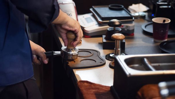 CHONBURI, THAILAND - 18 SEP : Barista hold coffee tamper at coffer bar for brew coffee on 18 September 2021 in cafe, Siracha, Chonburi, Thailand - Photo, image