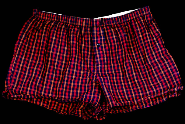 Red chequered mens boxer shorts on a black background - Foto, immagini