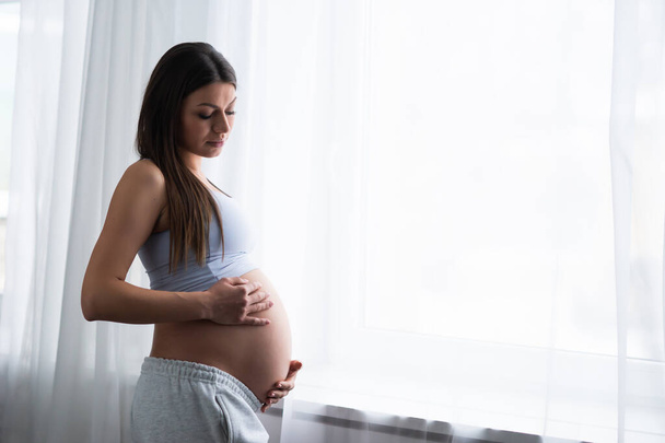 Une jeune femme enceinte se repose à la maison et attend un bébé. Grossesse, maternité, soins de santé et mode de vie. - Photo, image